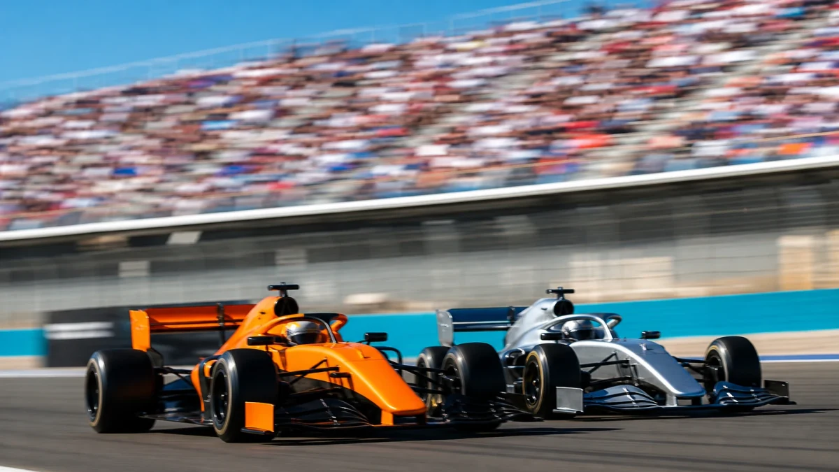 Två formel 1-bilar sida vid sida på en lång raksträcka i hög fart.