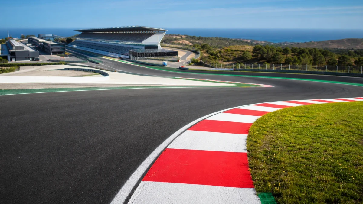 Kuperad racerbana i portugisiskt kustlandskap med tribuner och depåbyggnader inför en formel 1-helg.