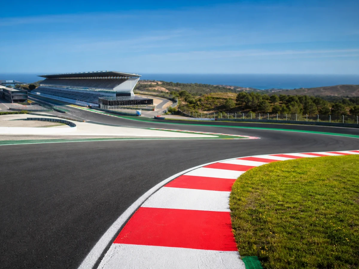 Kuperad racerbana i portugisiskt kustlandskap med tribuner och depåbyggnader inför en formel 1-helg.